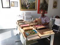 Josep Segura classificant les publicacions donades per Josep Vallverdú a l'Espai Macià.